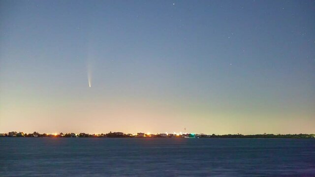Time lapse of C/2020 F3, or Comet Neowise, in the early morning sky with a gradient from orange sun glow to blue night sky. Long Island New York