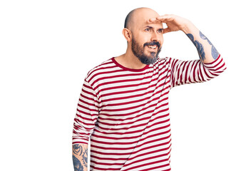 Obraz premium Young handsome man wearing casual clothes very happy and smiling looking far away with hand over head. searching concept.