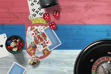 Serbia casino theme. Aces in poker game, cards and chips on red table with national wooden flag background. Gambling and betting.