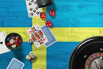 Sweden casino theme. Aces in poker game, cards and chips on red table with national wooden flag background. Gambling and betting.