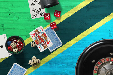 Tanzania casino theme. Aces in poker game, cards and chips on red table with national wooden flag background. Gambling and betting.