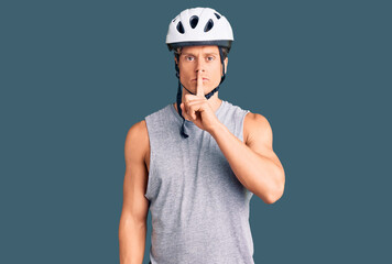 Young handsome man wearing bike helmet asking to be quiet with finger on lips. silence and secret concept.