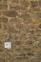 Bucket with heart hanging on a wall