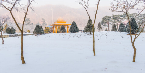 Winter landscape of golden colored gazebo