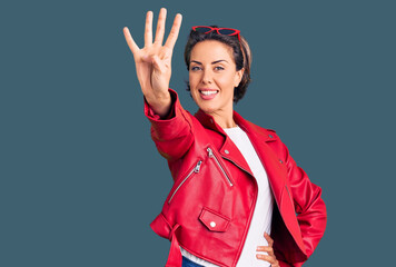 Young beautiful woman wearing red leather jacket showing and pointing up with fingers number four...