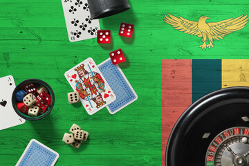 Zambia casino theme. Aces in poker game, cards and chips on red table with national wooden flag background. Gambling and betting.
