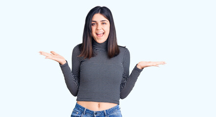 Young beautiful girl wearing striped t shirt celebrating victory with happy smile and winner expression with raised hands