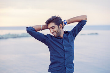 Man smiling hands on head taking deep breath enjoying life