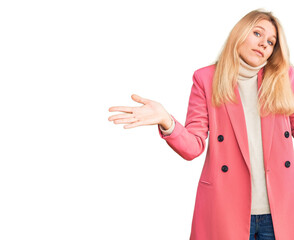 Young beautiful blonde woman wearing elegant clothes clueless and confused expression with arms and hands raised. doubt concept.