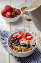 Homemade muesli bowl with strawberry, banana, nuts