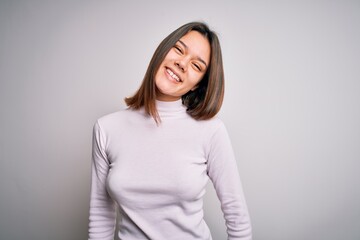 Young beautiful brunette girl wearing casual sweater standing over isolated white background with a happy and cool smile on face. Lucky person.
