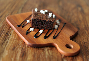Homemade Chocolate brownie topping with marshmallow on wooden background