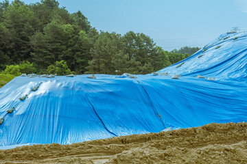 Dirt covered with blue tarp