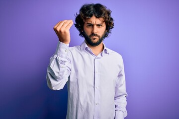 Young handsome business man with beard wearing shirt standing over purple background Doing Italian gesture with hand and fingers confident expression