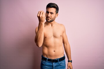 Fototapeta premium Young handsome strong man with beard shirtless standing over isolated pink background Doing Italian gesture with hand and fingers confident expression