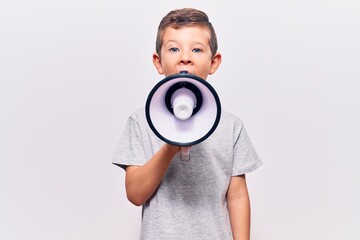 Adorable caucasian kid boy with angry expression. Screaming loud using megaphone standing over isolated white background