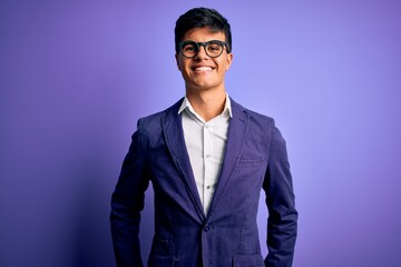 Young handsome business man wearing jacket and glasses over isolated purple background with a happy and cool smile on face. Lucky person.