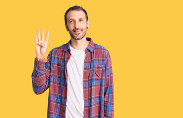 Fototapeta premium Young handsome man wearing casual clothes showing and pointing up with fingers number four while smiling confident and happy.