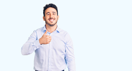 Young hispanic man wearing business clothes doing happy thumbs up gesture with hand. approving expression looking at the camera showing success.