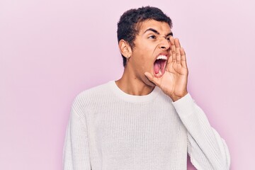 Young african amercian man wearing casual clothes shouting and screaming loud to side with hand on mouth. communication concept.