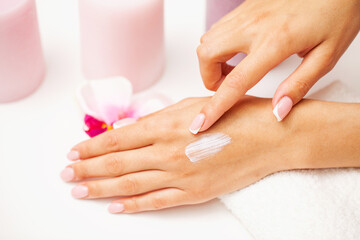 Obraz na płótnie Canvas Woman close up applies moisturizer for hand skin care