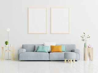 Poster mockup with vertical frame standing on floor in living room interior with gray sofa.