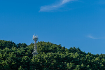 Fototapeta na wymiar Cellphone tower under clear blue sky
