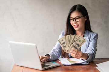 Dollar in a businesswoman hand. An Asia woman is working from home or office and glad to get dollar...