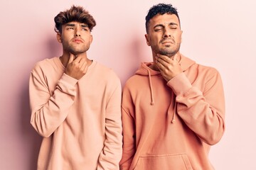 Young gay couple wearing casual clothes touching painful neck, sore throat for flu, clod and infection