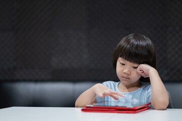 kid using tablet on the table, child watching cartoon