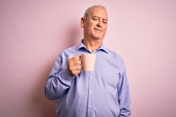 Middle age handsome hoary man drinking mug of coffee over isolated pink background with a happy face standing and smiling with a confident smile showing teeth