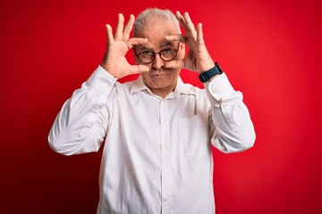 Middle age handsome hoary man wearing casual shirt and glasses over red background Trying to open eyes with fingers, sleepy and tired for morning fatigue