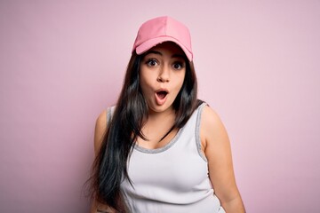 Young brunette woman wearing casual sport cap over pink background afraid and shocked with surprise expression, fear and excited face.