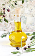 olive oil in a bottle and a sprig of fresh olives. copy space