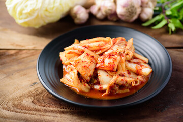 Kimchi cabbage on black plate with wooden background, Korean food