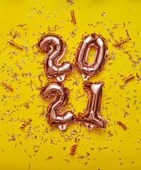 Shiny balloon symbols 2021 with glitters on festive background.