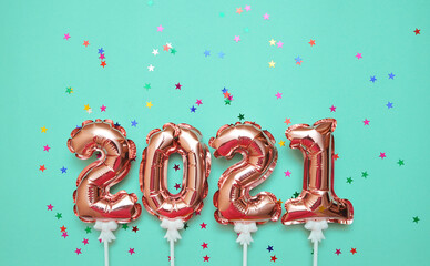 Shiny balloon symbols 2021 with glitters on festive background.