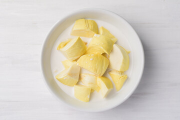 Thai dessert, sliced durian fruit with coconut milk in a bowl on white table background
