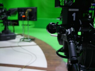 handle of professional studio camera with virtual greenscreen at TV station.