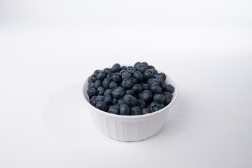 Bowl of fresh blueberries shot from a high angle on a white background with room for copy