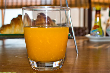 This unique photo the super delicious fresh orange juice in a glass on a wooden table! the picture was taken in thailand