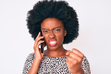 Young african american woman having conversation talking on the smartphone annoyed and frustrated shouting with anger, yelling crazy with anger and hand raised