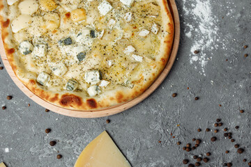 four cheese pizza, italian pizza. pizza stuffed with four varieties of cheese on a gray background.