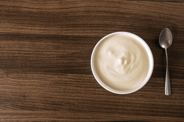 Sour cream yogurt in white bowl  on table. Top view