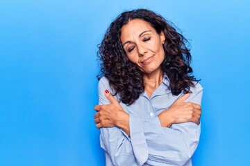 Middle age beautiful woman wearing casual shirt hugging oneself happy and positive, smiling confident. self love and self care