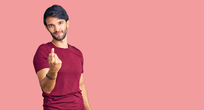 Handsome hispanic man wearing casual clothes beckoning come here gesture with hand inviting welcoming happy and smiling