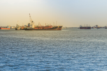 Massive container ship for import export and business logistic. Big cargo ship is leaving from Bangkok Port Authority of Thailand or Klong Toey port along Chao Phraya river in Bangkok,Thailand.
