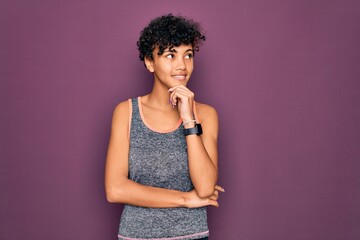 Young beautiful african american afro sportswoman doing exercise wearing sportswear with hand on chin thinking about question, pensive expression. Smiling and thoughtful face. Doubt concept.