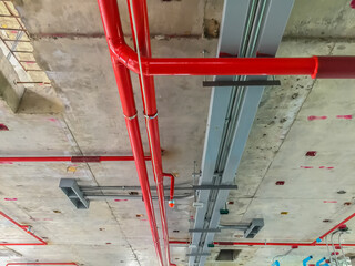 Red fire extinguisher pipe lines under construction on the ceiling.