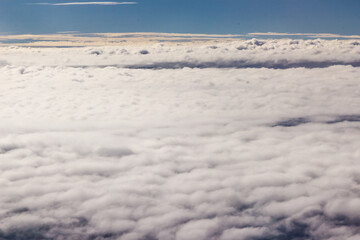 Beautiful cloudscape and blue sky from aerial view, nature view from above the sky and clouds. White clouds and blue sky view like the heaven from airplane window. Sunlight in the sky shines on clouds